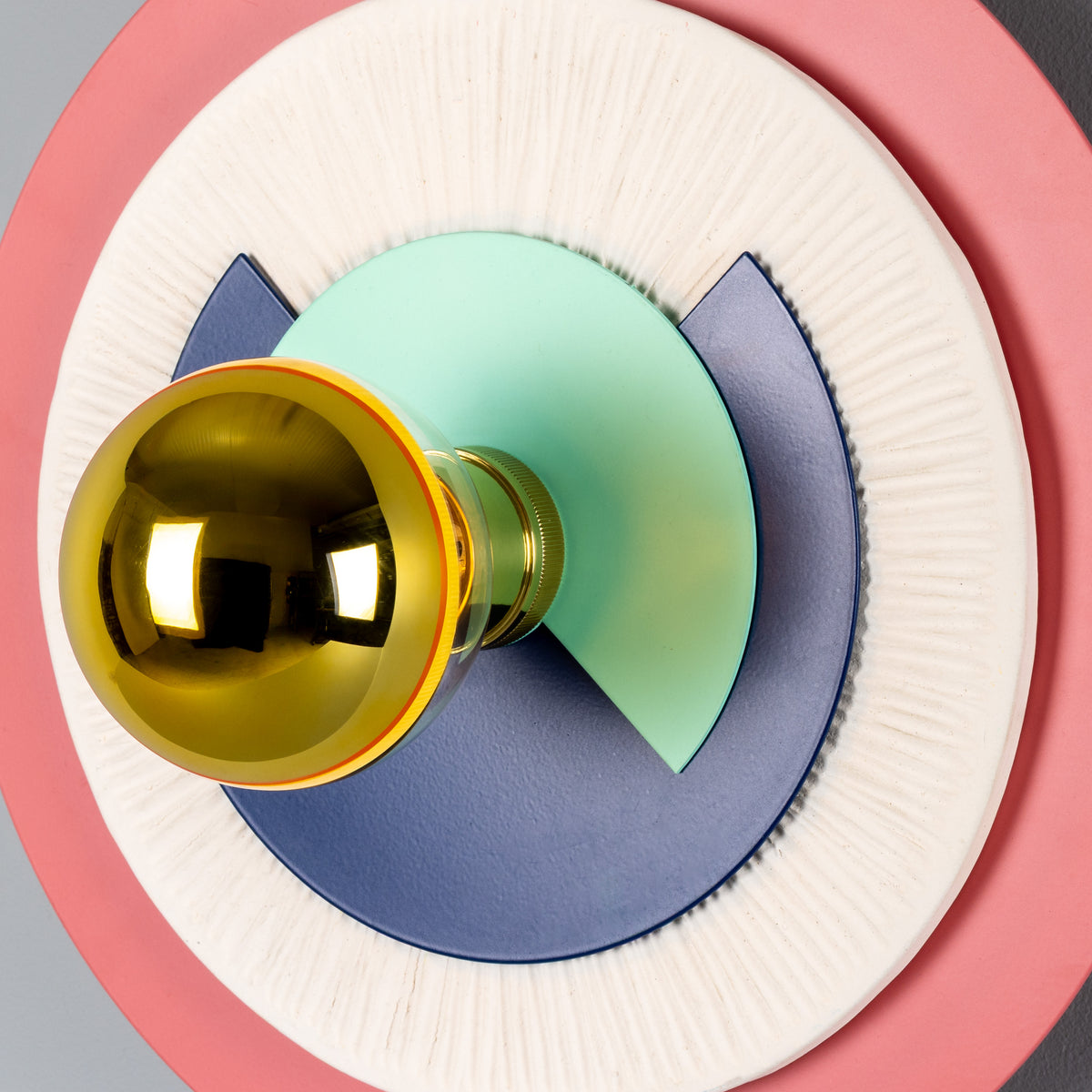 Mullan Saturn colourful disc wall light with polished brass bulb and layered geometric plates