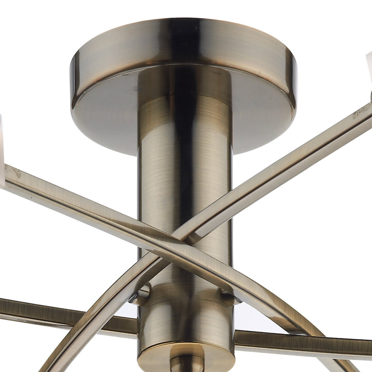 Close-up of a brass ceiling light fixture with intersecting arms.