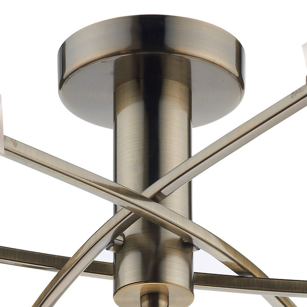 Close-up of a brass ceiling light fixture with intersecting arms.