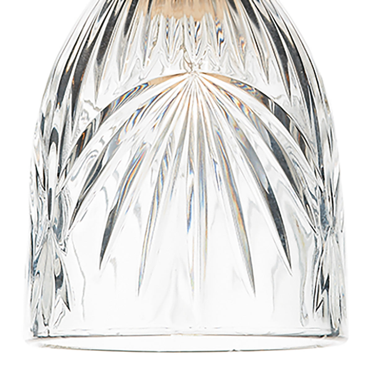 Close-up of a clear glass with intricate, radiating cut patterns.