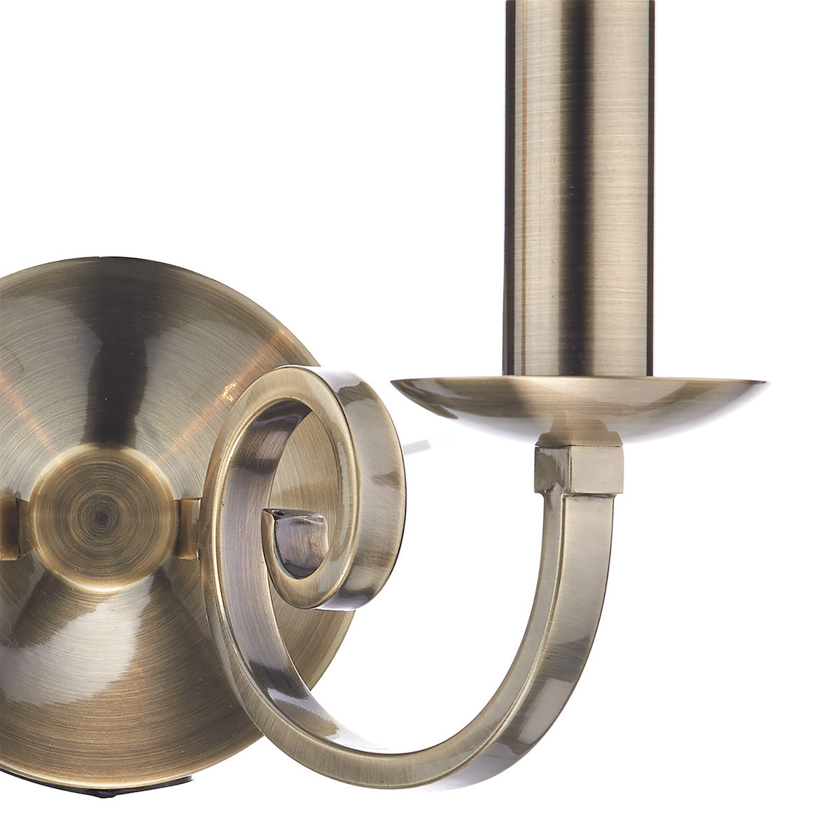 Close-up of a brass wall sconce with a decorative scroll arm and a candle holder.