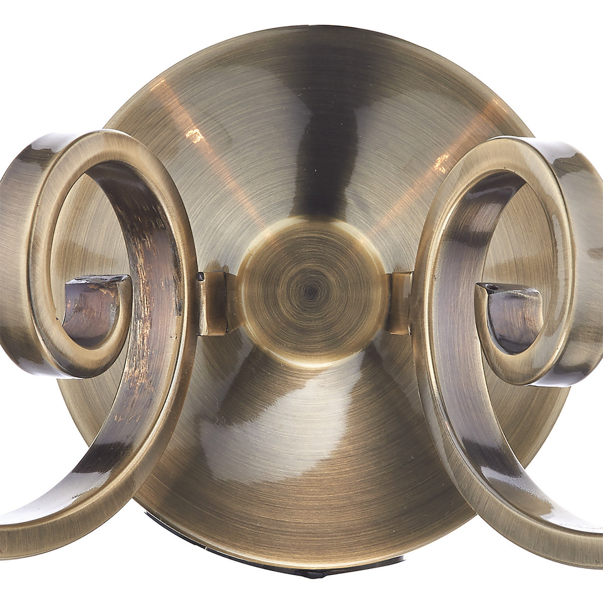 Close-up of a brass wall sconce with two ornate, scrolled arms.