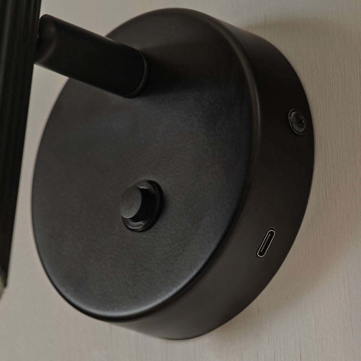 Close up of a black wall-mounted light fixture with a USB-C port and a dimmer switch