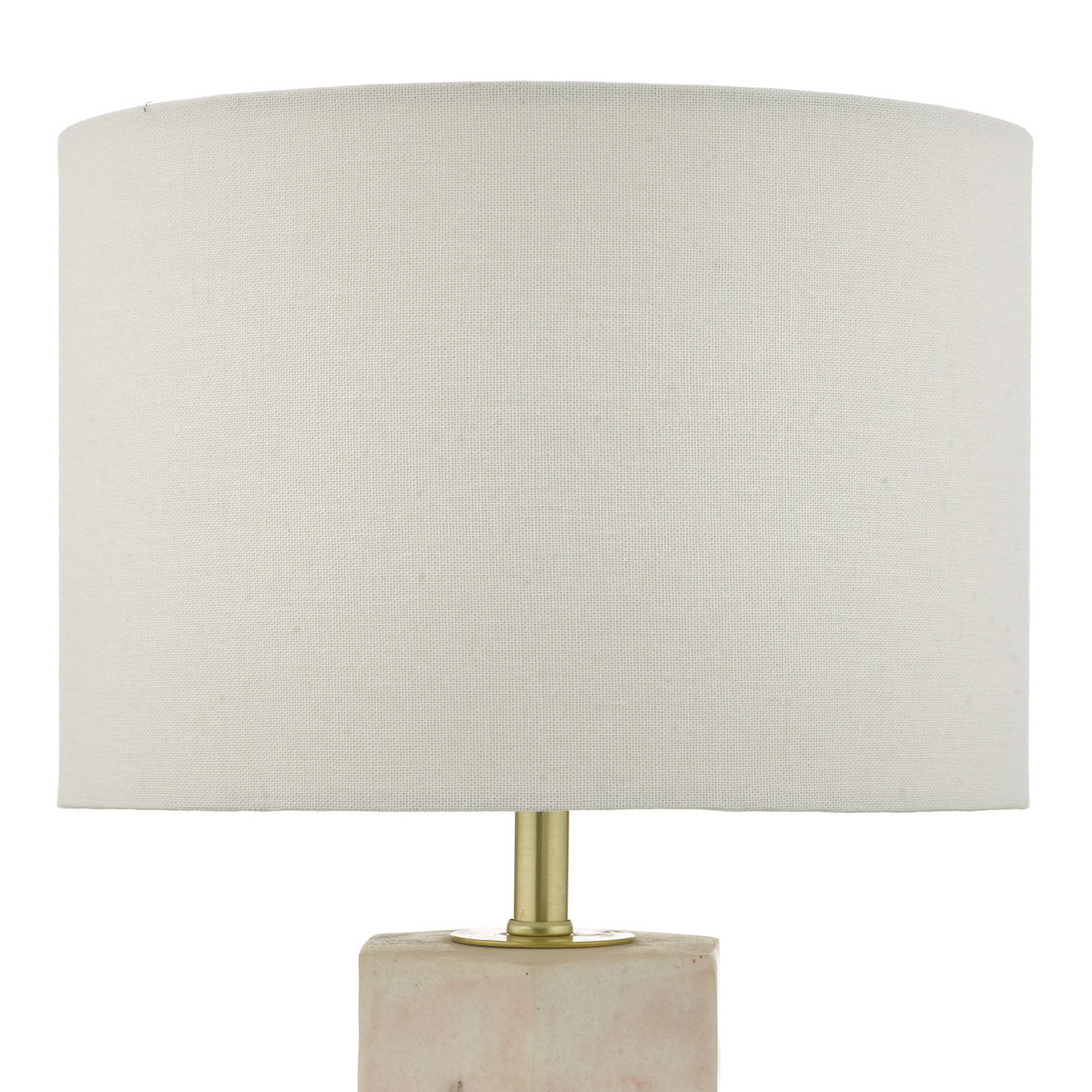 Close-up of a table lamp with a white fabric shade and a rectangular, light pink marble base.