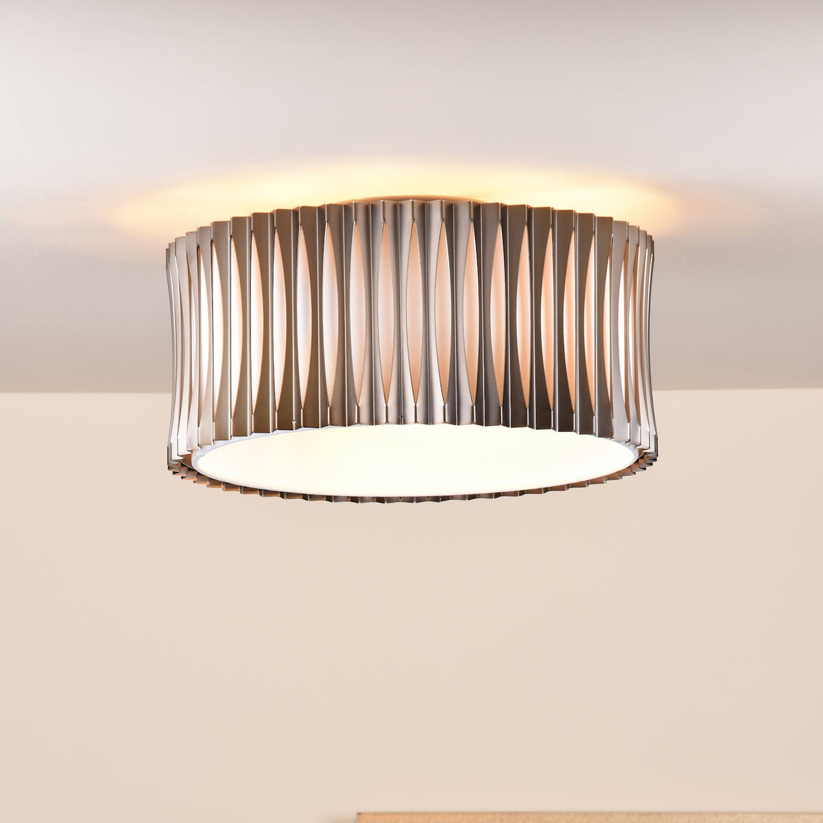 Round ceiling light with a brushed metal shade and a white diffuser