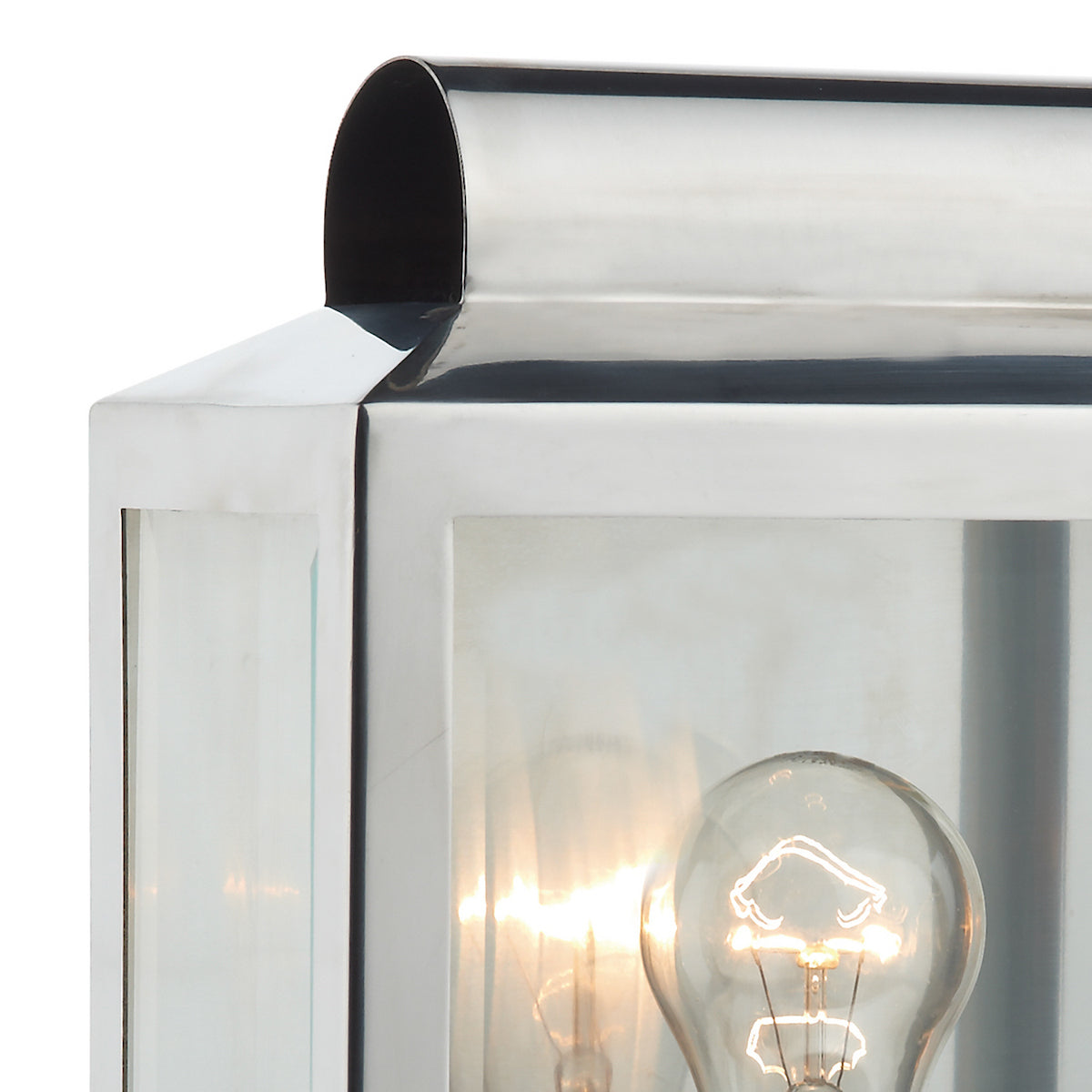 Close-up of a polished chrome outdoor lantern with a glowing light bulb inside.