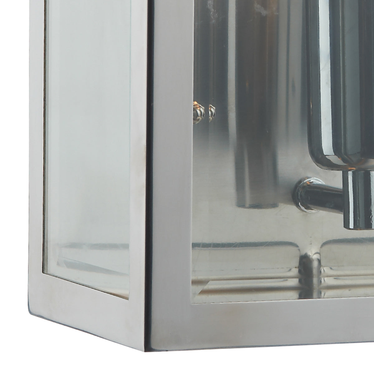 Close-up of a stainless steel and glass outdoor wall light.