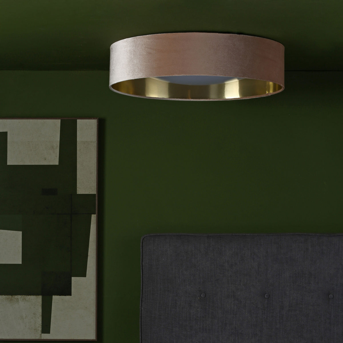 A beige velvet ceiling light with a gold interior on a dark green ceiling