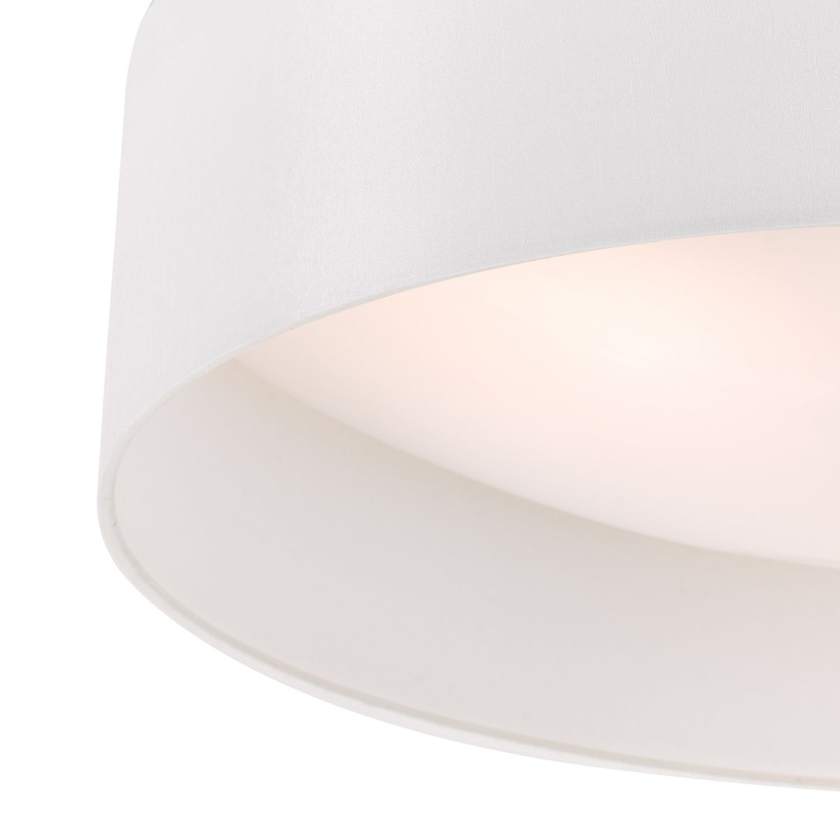 Close up of a white fabric drum lampshade with light glowing from within