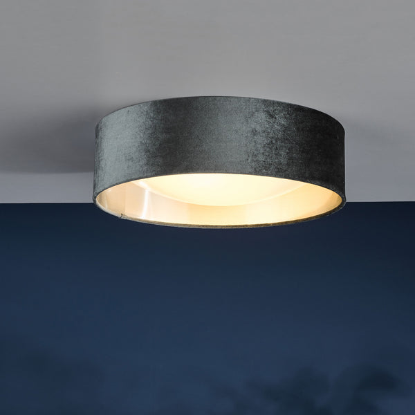 Round ceiling light with a dark grey velvet shade and a warm glow