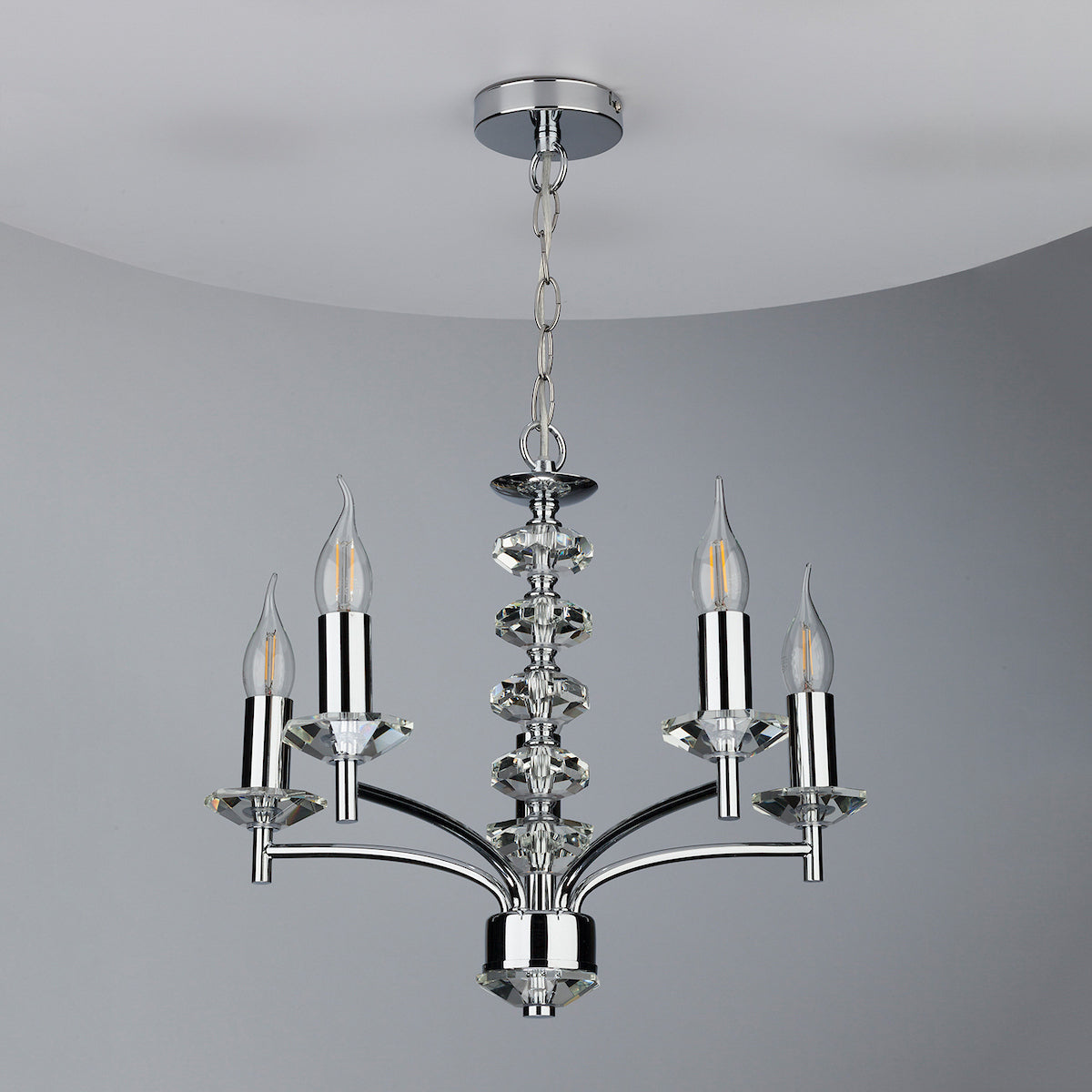A modern chrome chandelier with four candle-style bulbs and crystal accents.