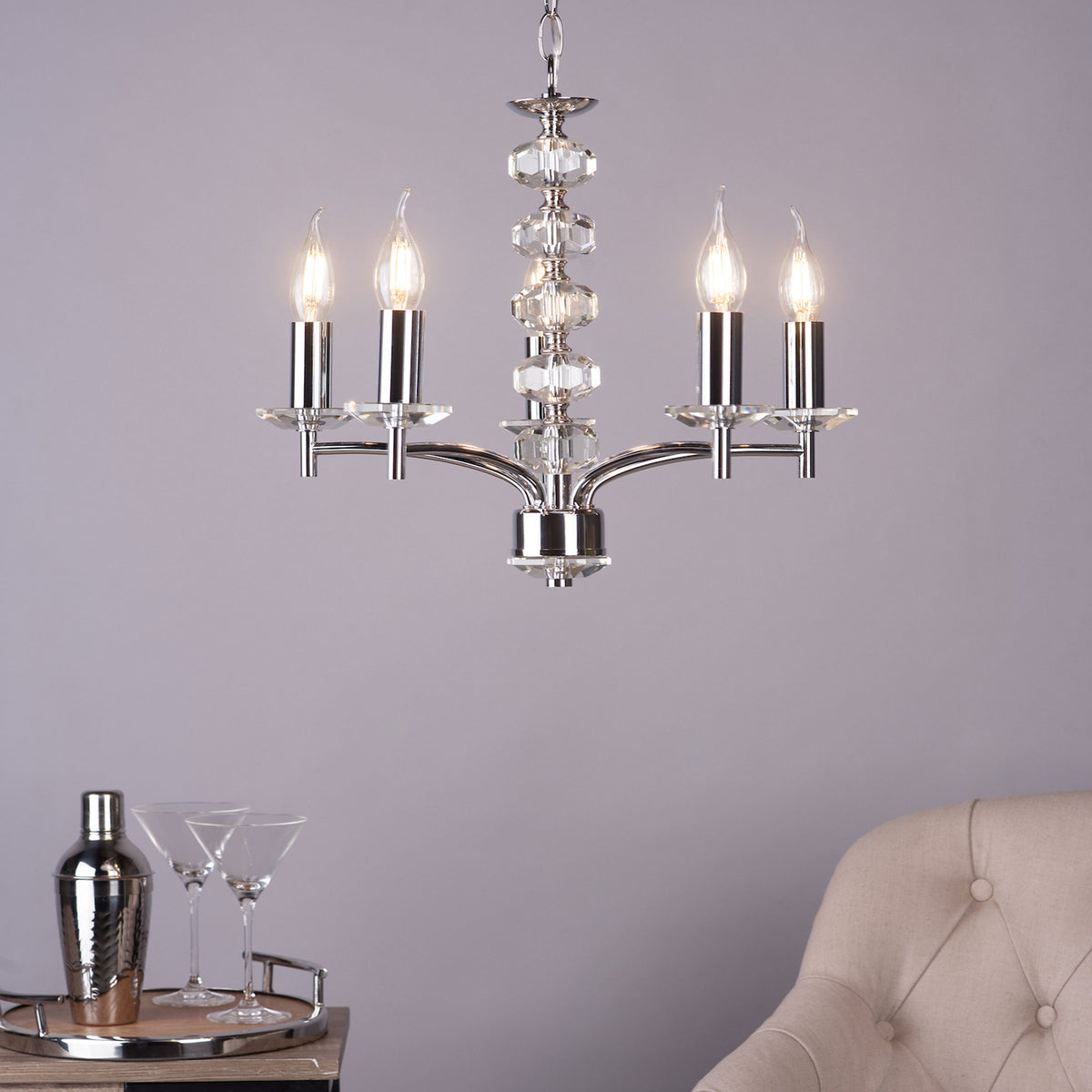 A polished chrome chandelier with four candle-style lights and crystal accents hangs from the ceiling.