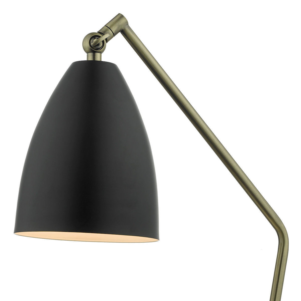 Close-up of a black lamp shade with a brass adjustable arm, emitting a warm glow.