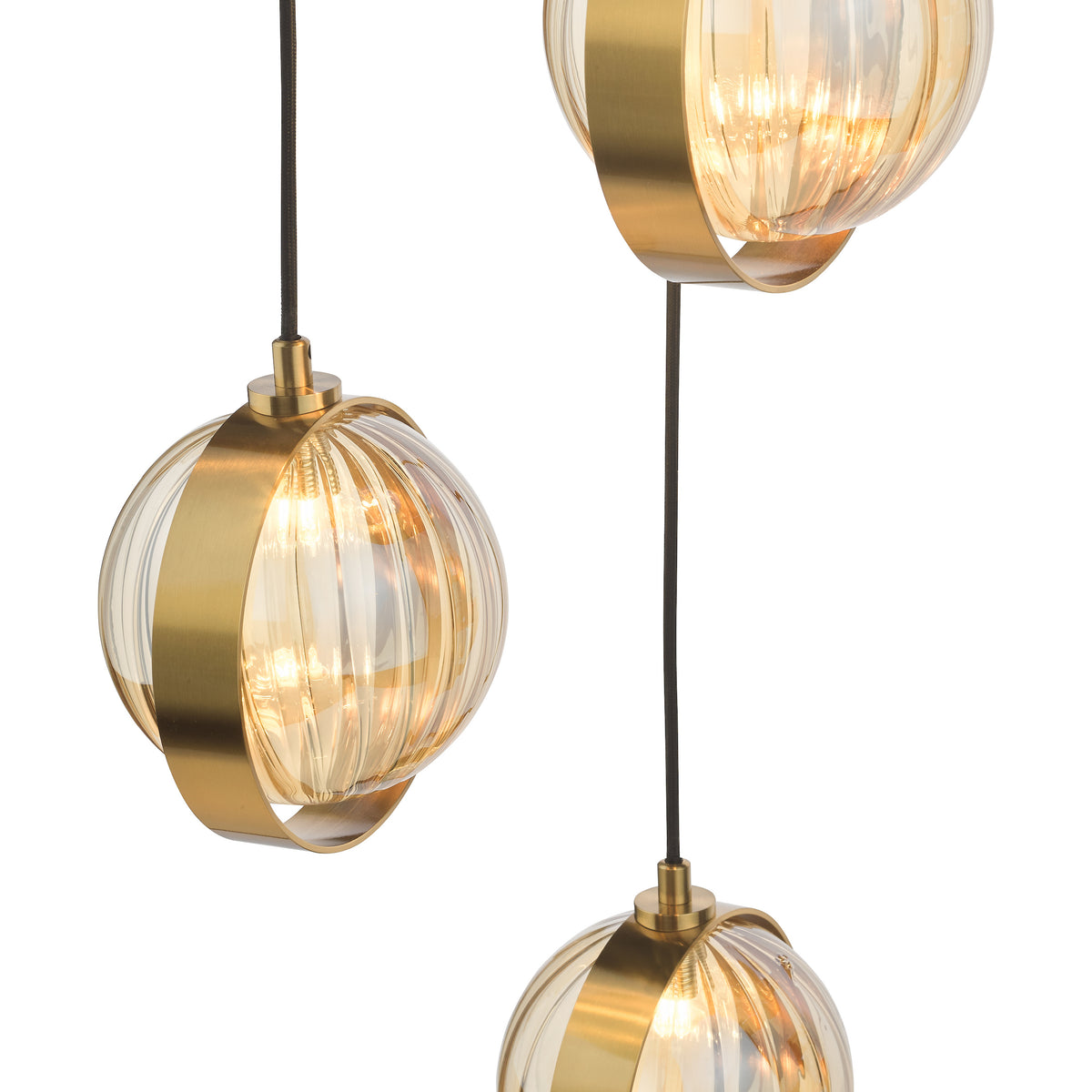 Three pendant lights with ribbed amber glass shades and brass bands, hanging from black cords.