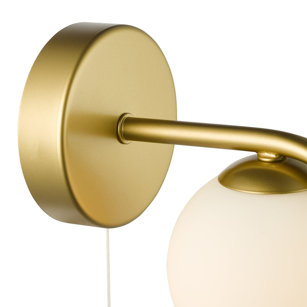 Close-up of a gold wall light with a white spherical shade and a pull cord switch