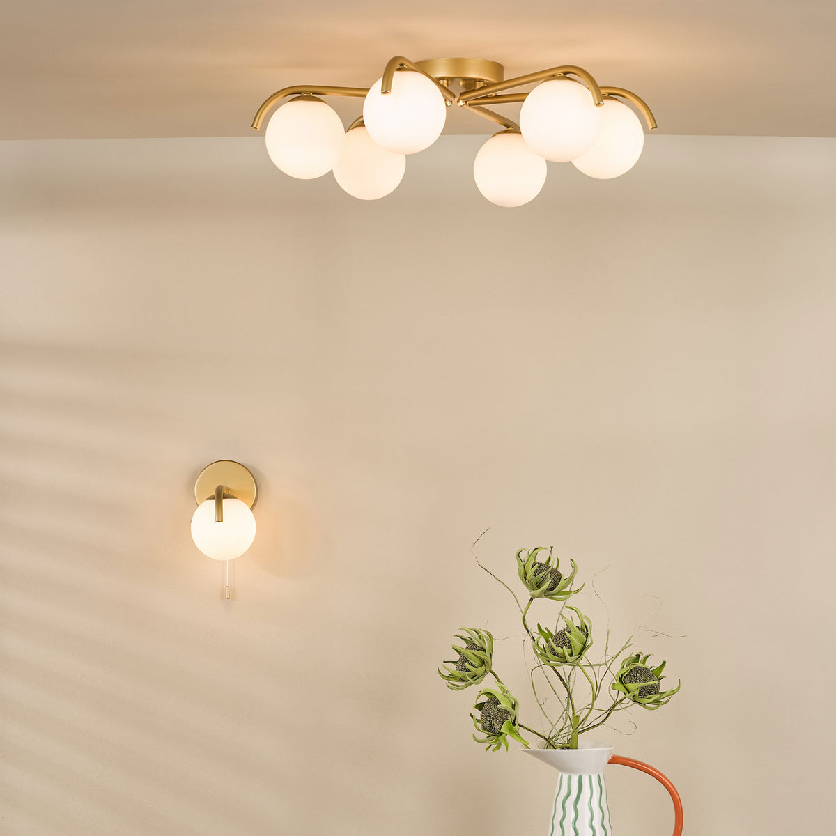 Gold ceiling light with six globe bulbs and a matching wall light with one globe bulb
