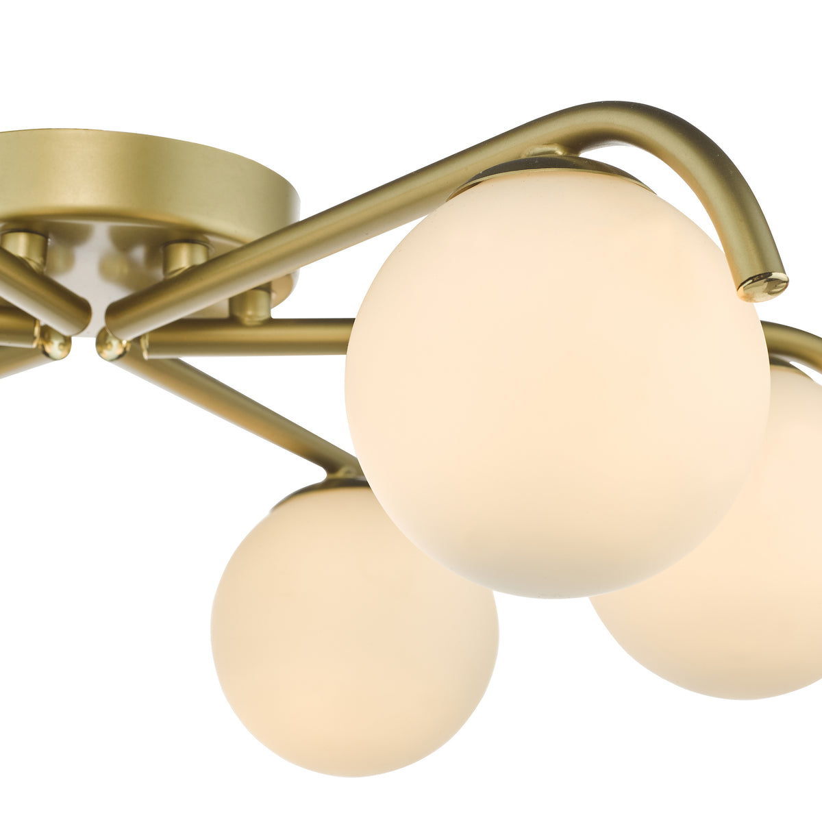 Close up of a gold ceiling light with three spherical white glass shades