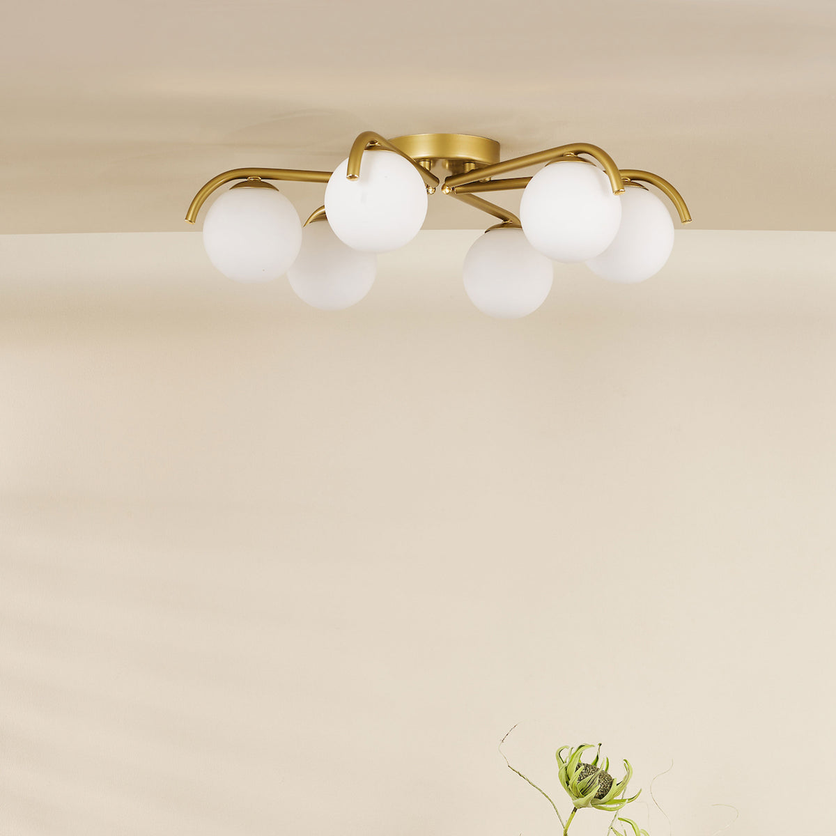 Gold ceiling light with five white globe shades