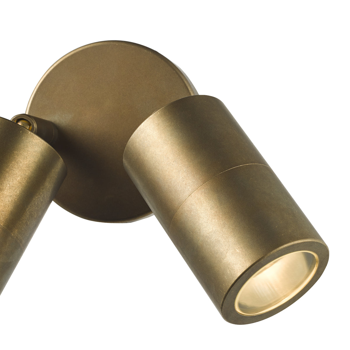 Two cylindrical bronze-colored spotlights on a circular base, one angled down and illuminated