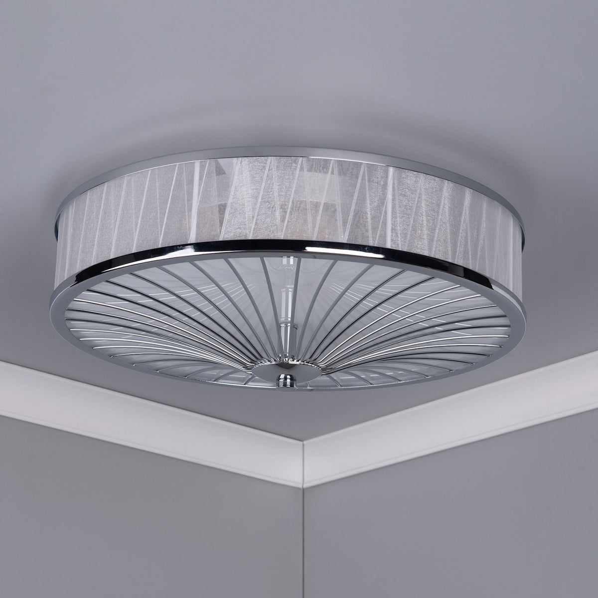 A round, flush-mount ceiling light with a sheer, textured fabric shade and a chrome-finished base.