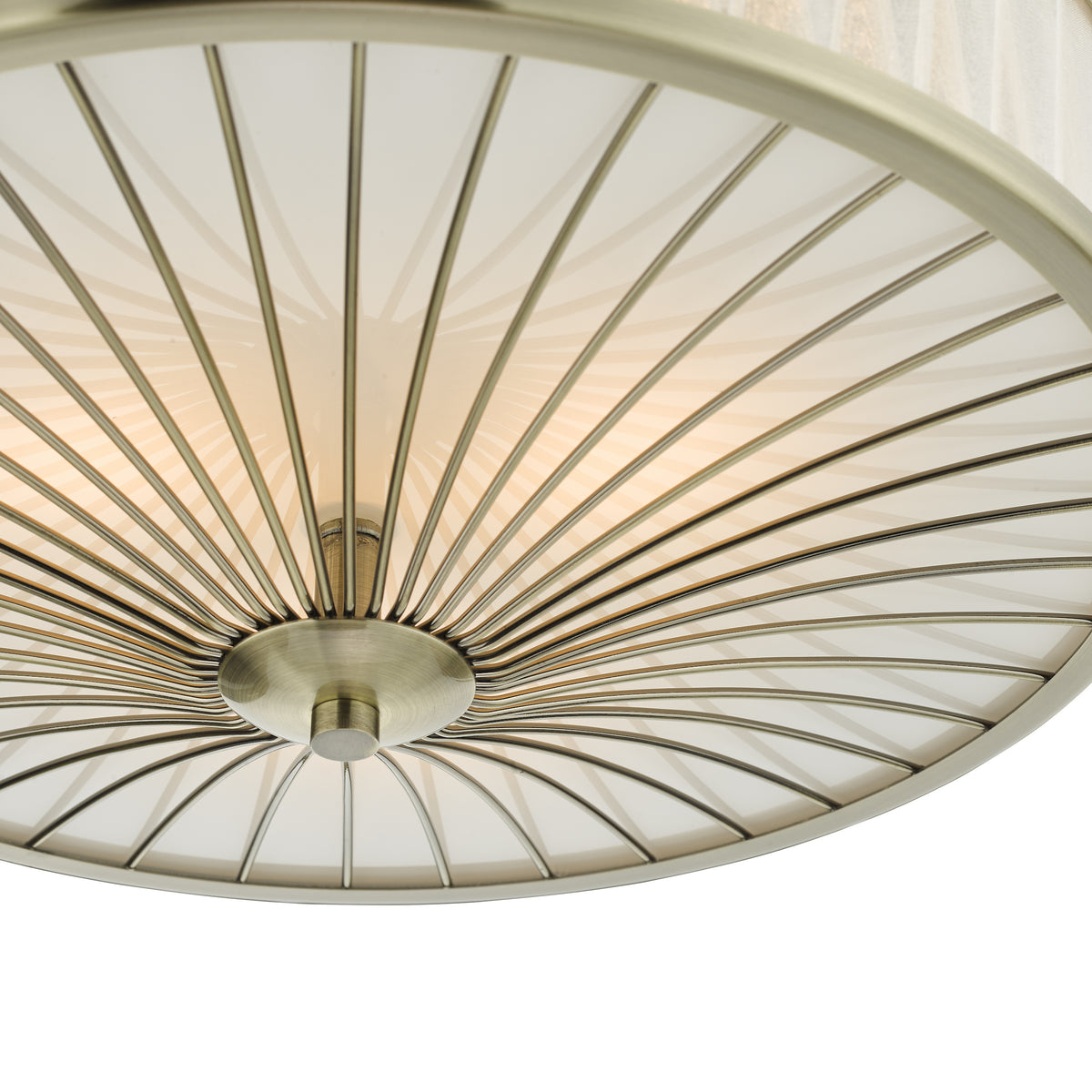 Close up of a ceiling light with a brass frame and a white diffuser