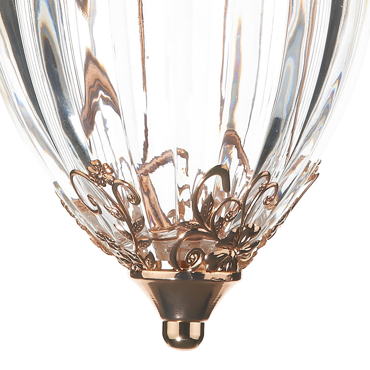 Close-up of a clear glass light fixture with a decorative bronze base and floral accents.