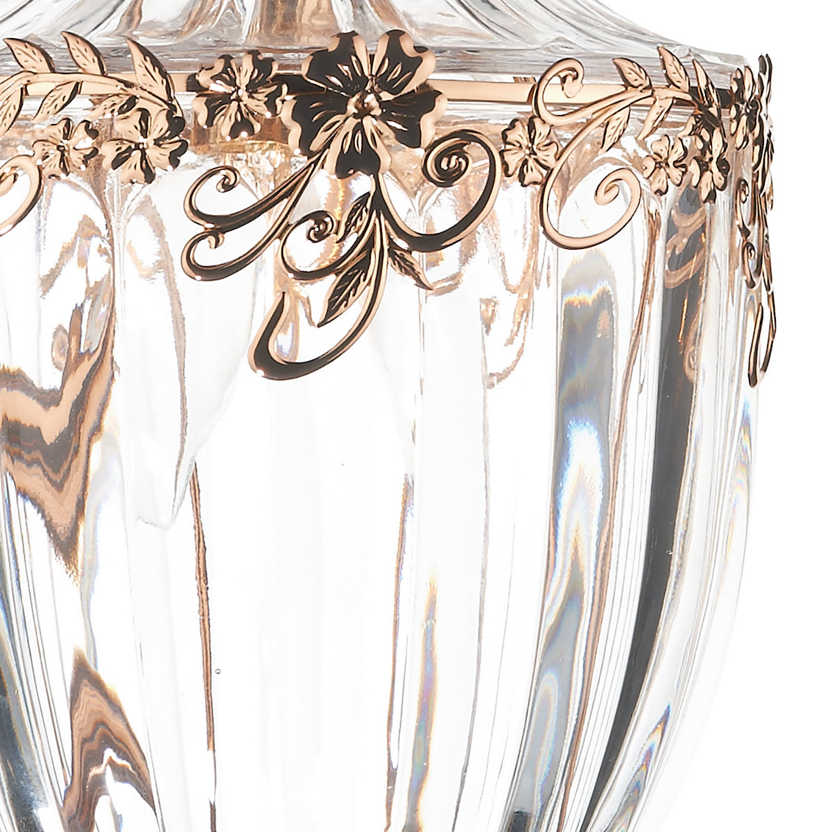 Close-up of a clear glass vase with a gold floral design around the rim.