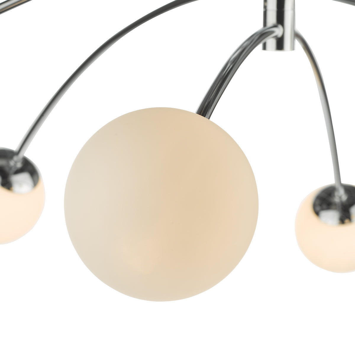 Close-up of a modern chandelier with three spherical, frosted glass shades and chrome arms.
