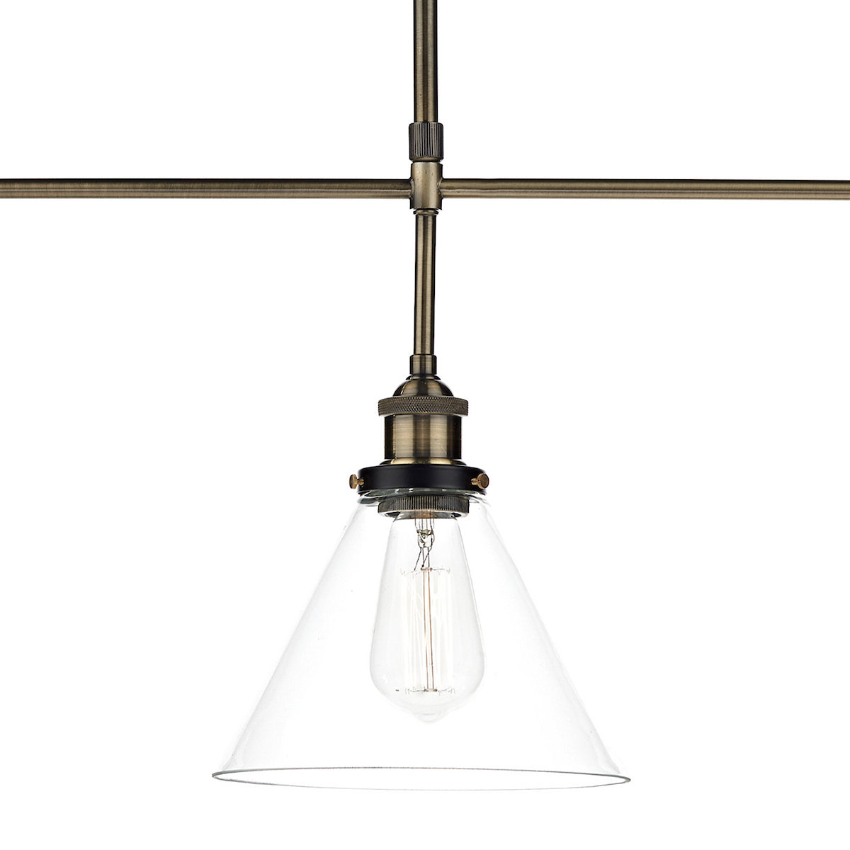 Close-up of a brass pendant light with a clear conical shade and exposed filament bulb.