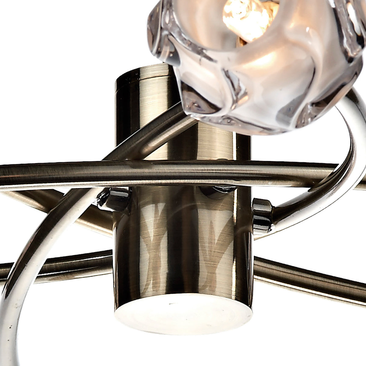 Close-up of a modern light fixture with brushed brass and chrome accents, featuring a clear glass shade.
