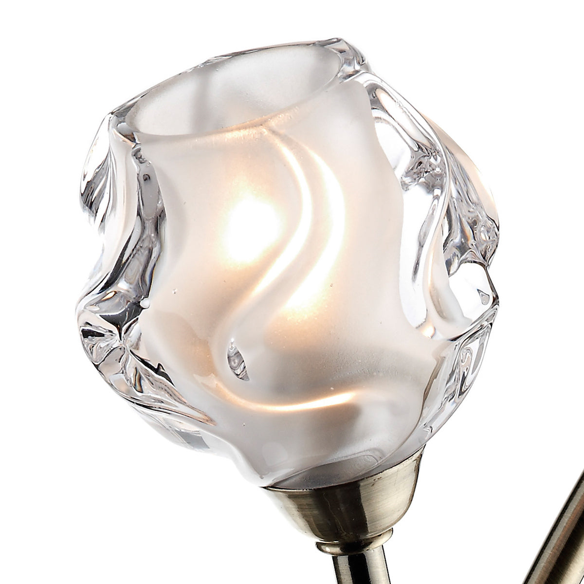 Close-up of a frosted glass light shade with a clear, wavy top edge, glowing from within.