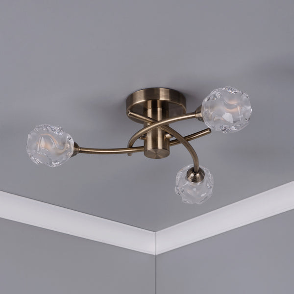 Bronze ceiling light with three frosted glass shades, mounted on a gray ceiling with white crown molding.
