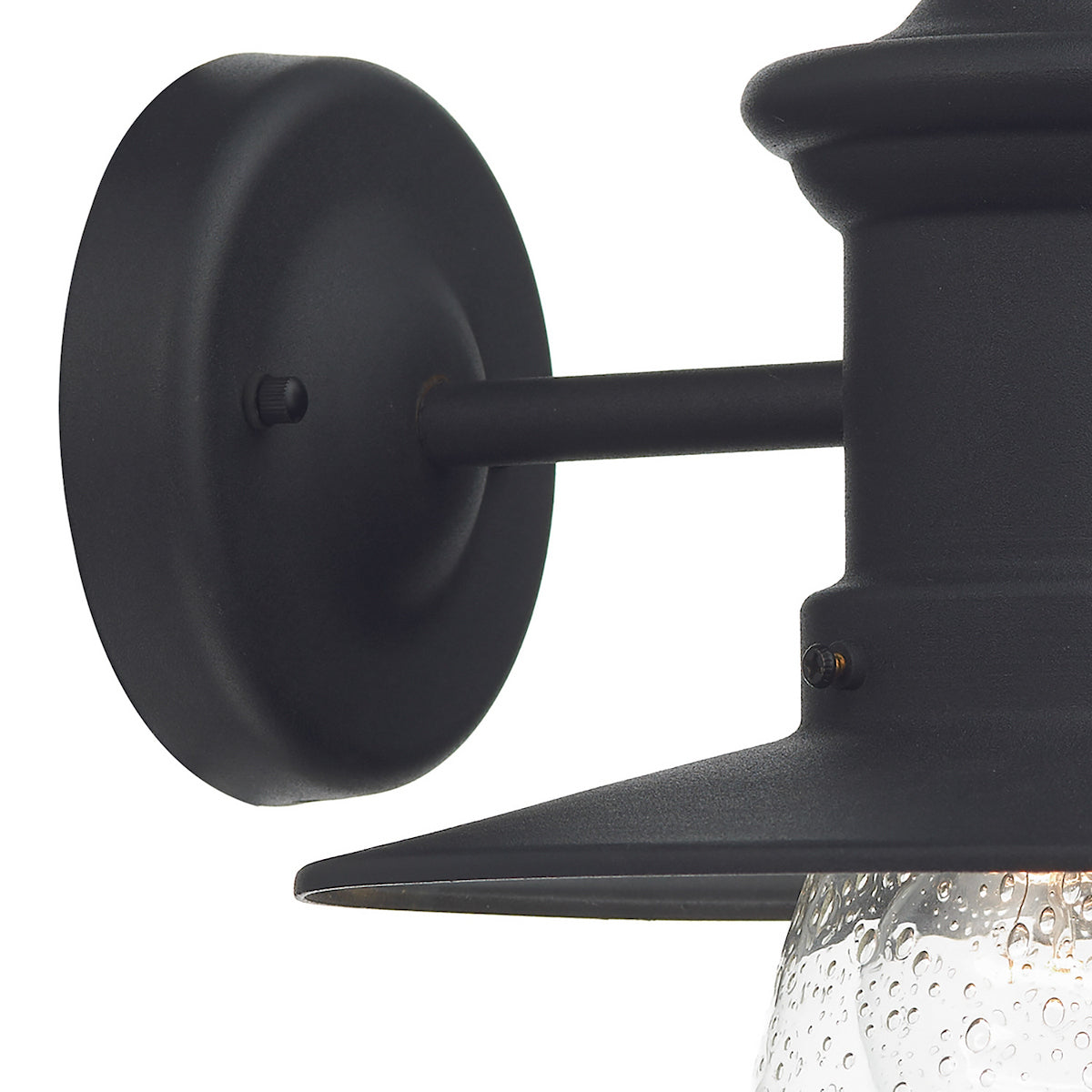 Close-up of a black outdoor wall light with a seeded glass shade.