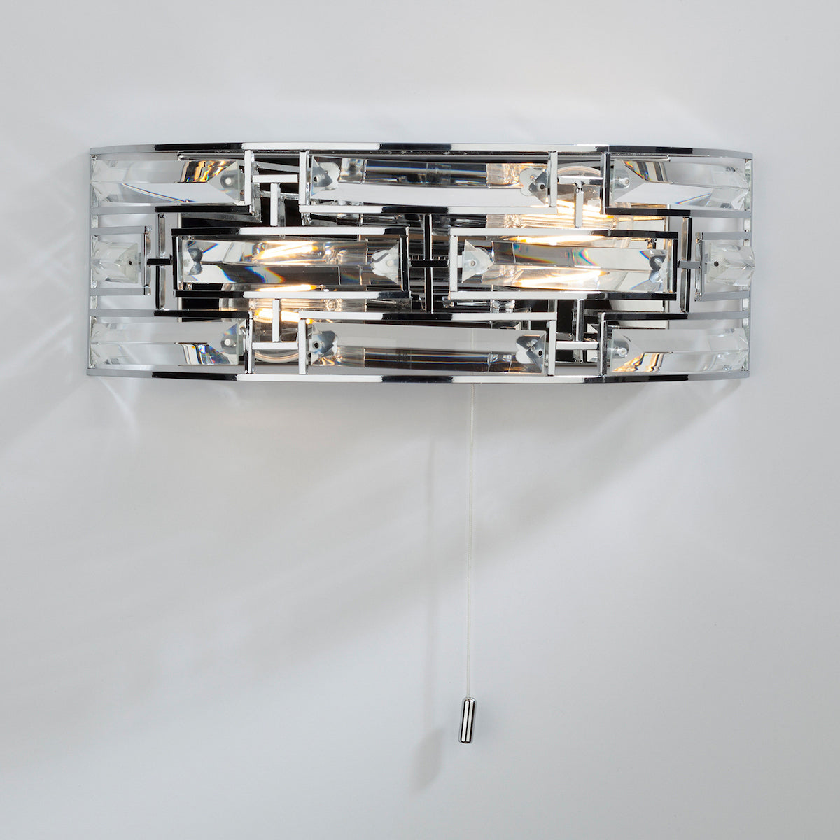 Rectangular chrome wall light with clear crystal blocks and a pull cord switch.
