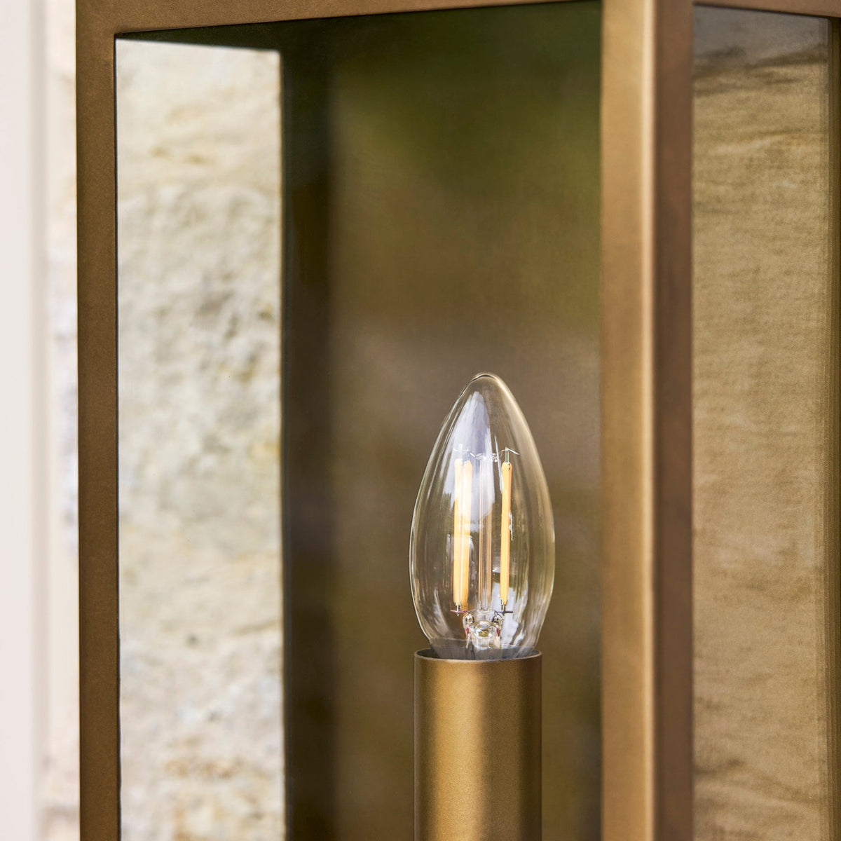 Close up of the Sandford Outdoor Single Box Lantern in antique brass showing the light bulb