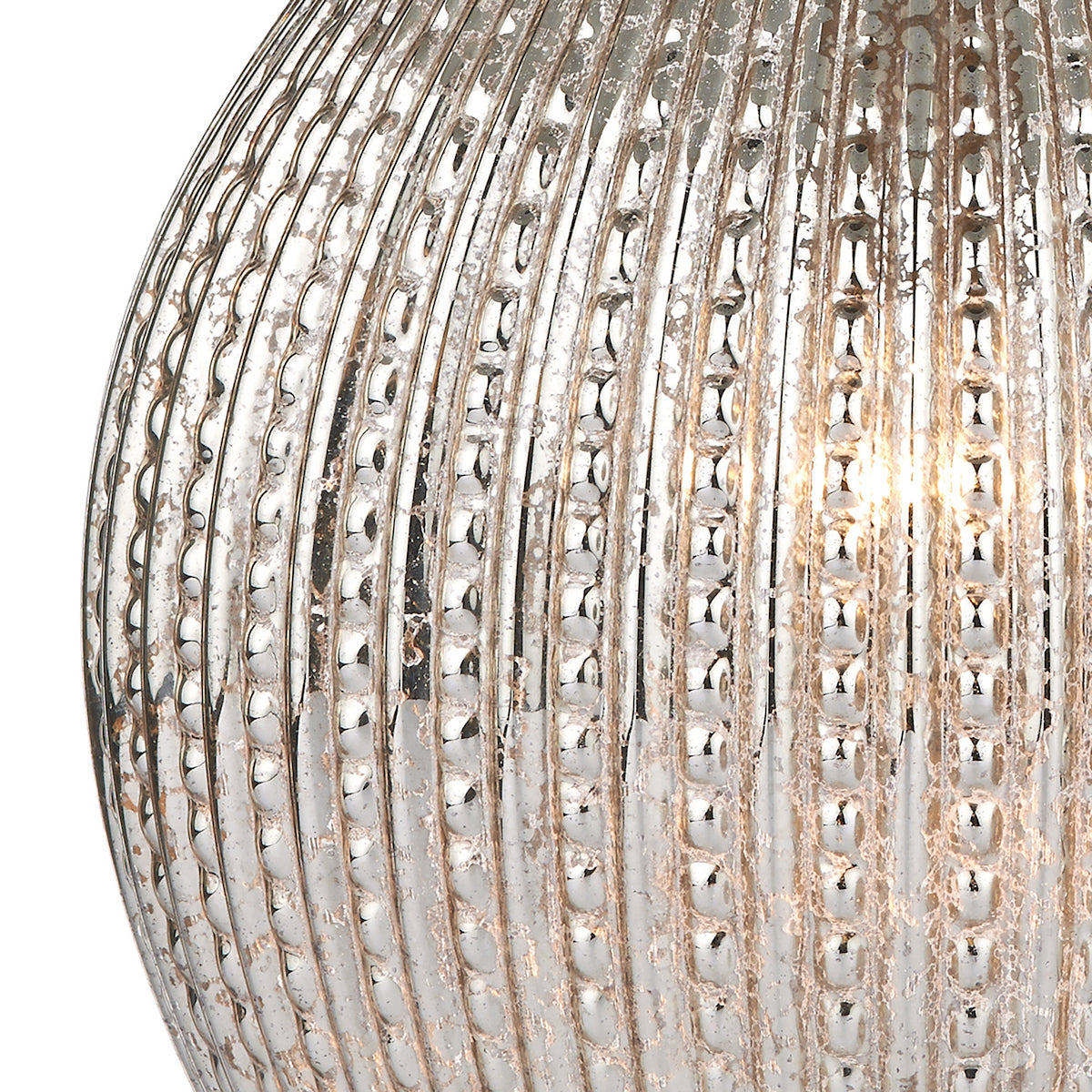 Close-up of a mercury glass lamp with vertical ribbed texture and a warm glow from within.