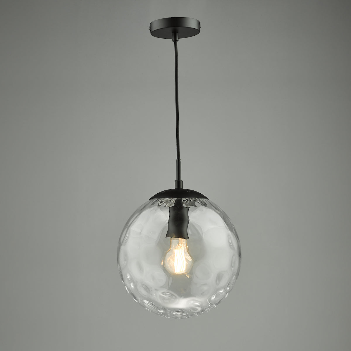 Textured clear glass globe pendant light with a black fixture and exposed bulb.