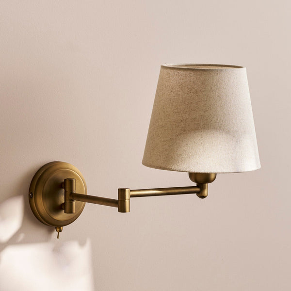 Brass swing arm wall lamp with a tapered fabric shade