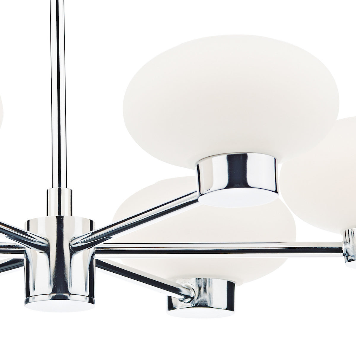 Close-up of a modern chandelier with chrome arms and frosted white globe lights.