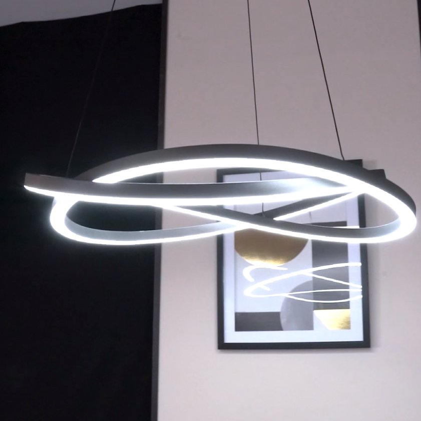 Modern LED chandelier with intertwined rings, illuminating a room with a framed abstract art piece in the background