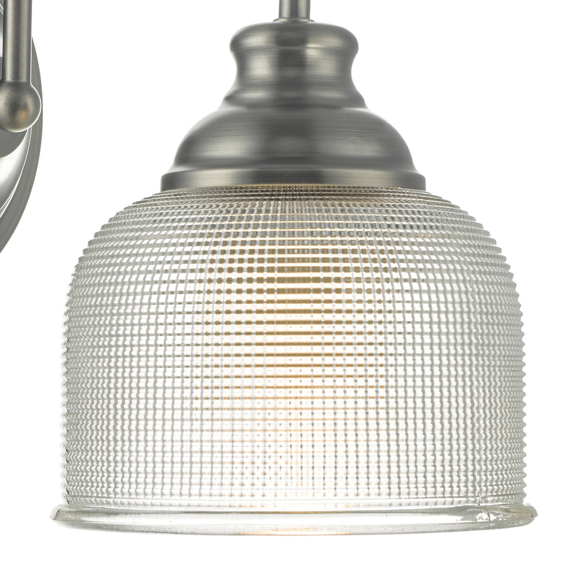 Close-up of a brushed nickel light fixture with a ribbed, clear glass shade.