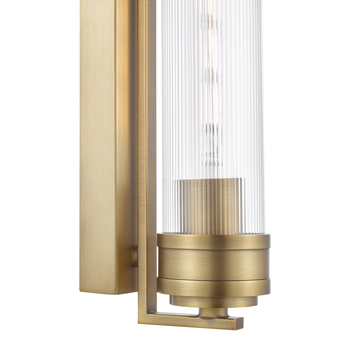 Close up of a brass wall sconce with a ribbed glass shade