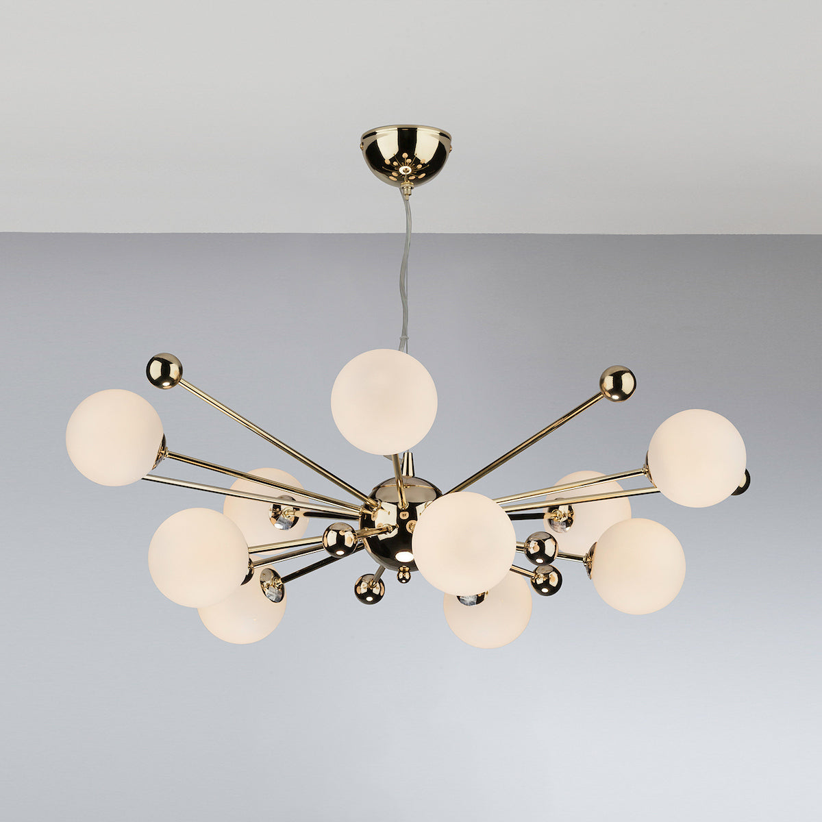 Modern gold chandelier with multiple white globe lights extending from a central sphere.