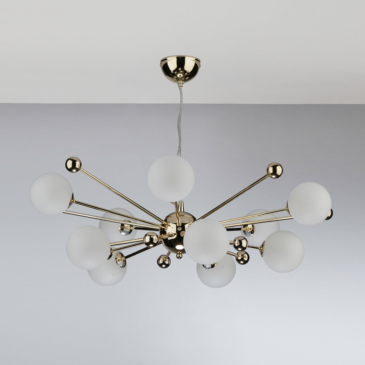 Modern gold chandelier with multiple white spherical lights extending from a central hub.