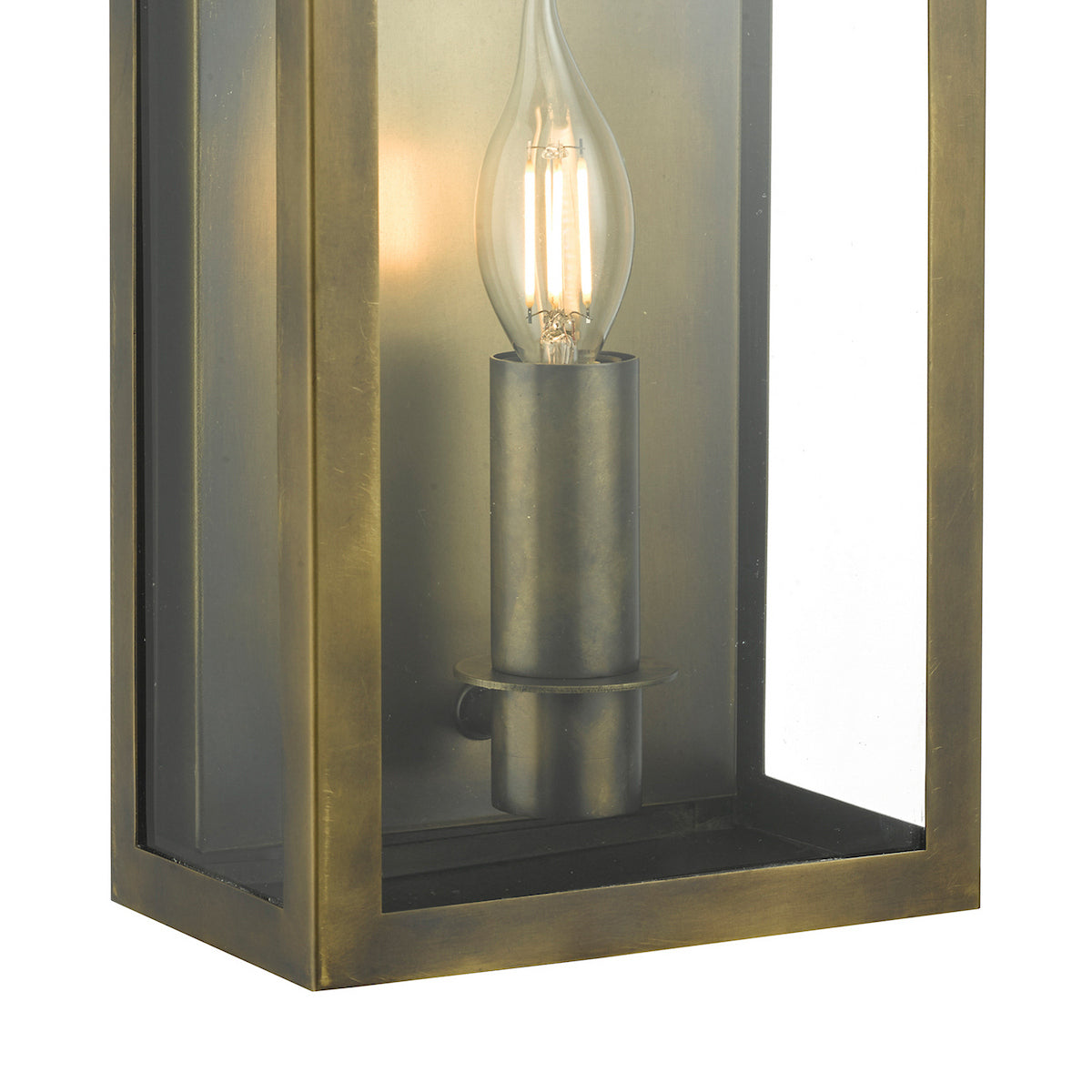 Close-up of a bronze outdoor wall light with a clear glass panel and a lit candle-style bulb.