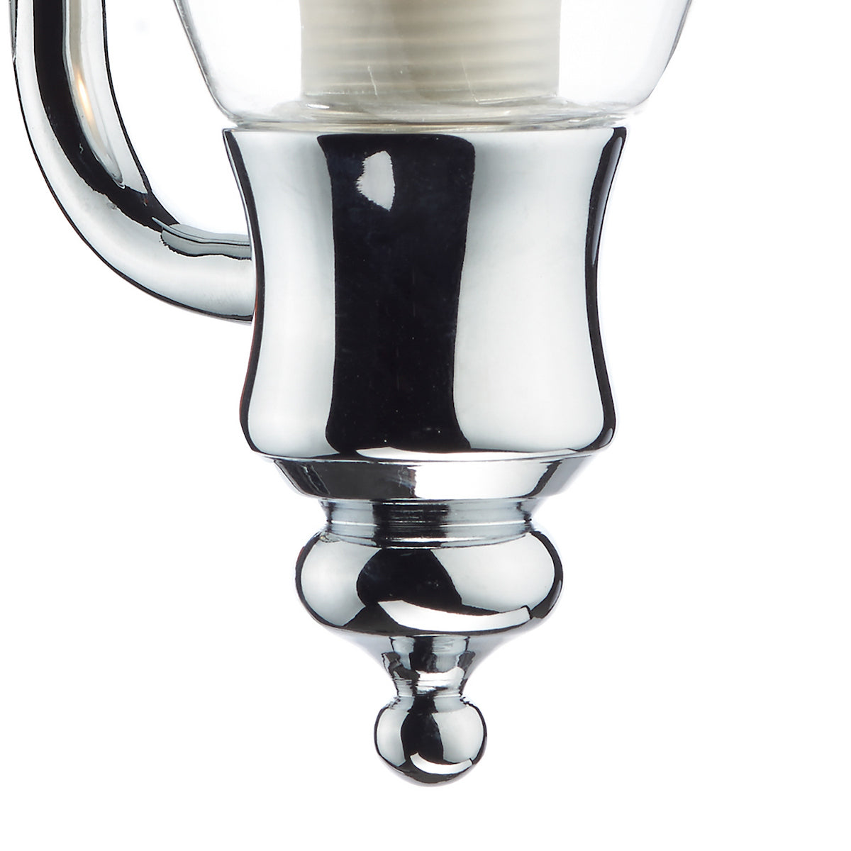 Close-up of a chrome light fixture with a clear glass shade and decorative finial.