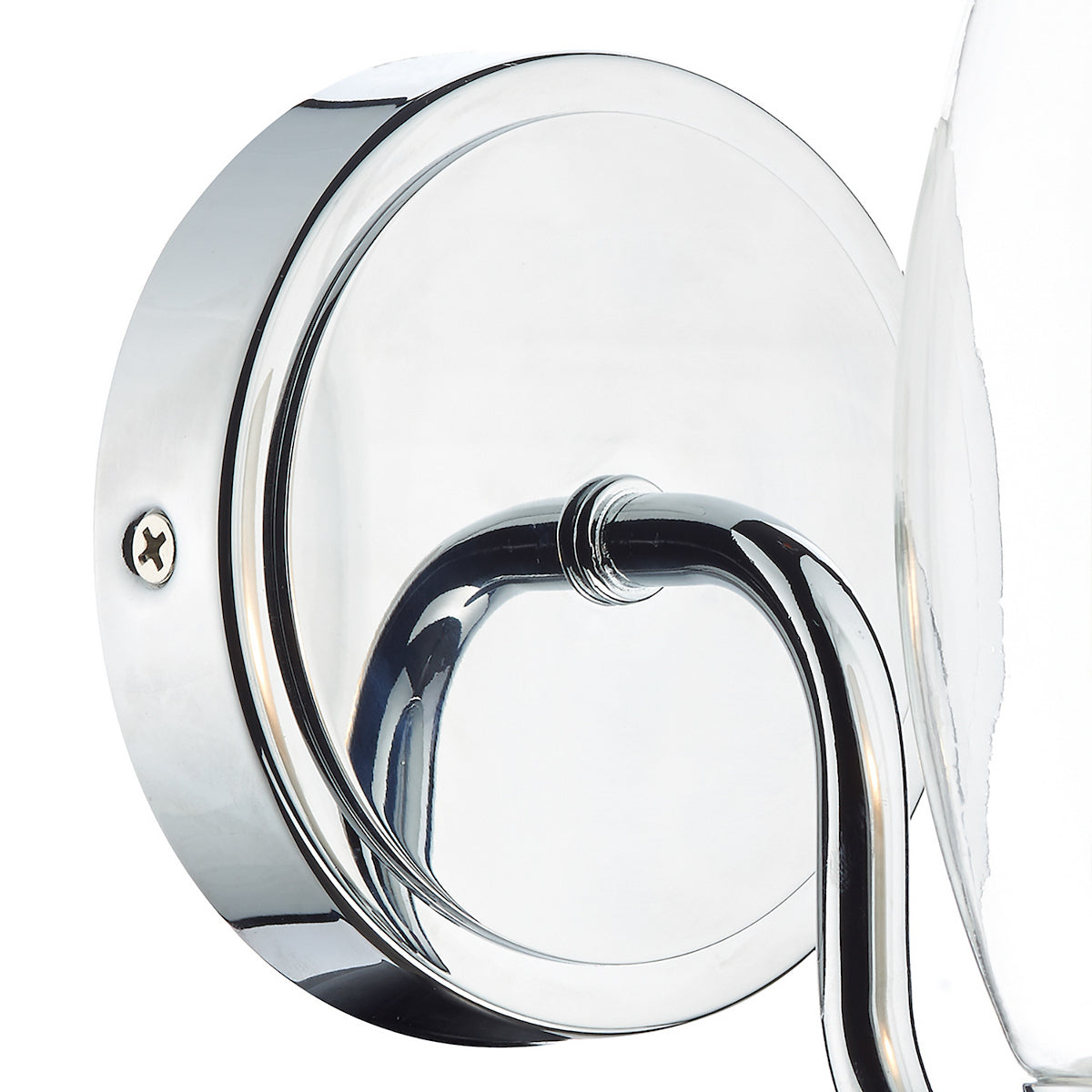 Close-up of a chrome wall sconce base with a curved arm and a clear glass shade.