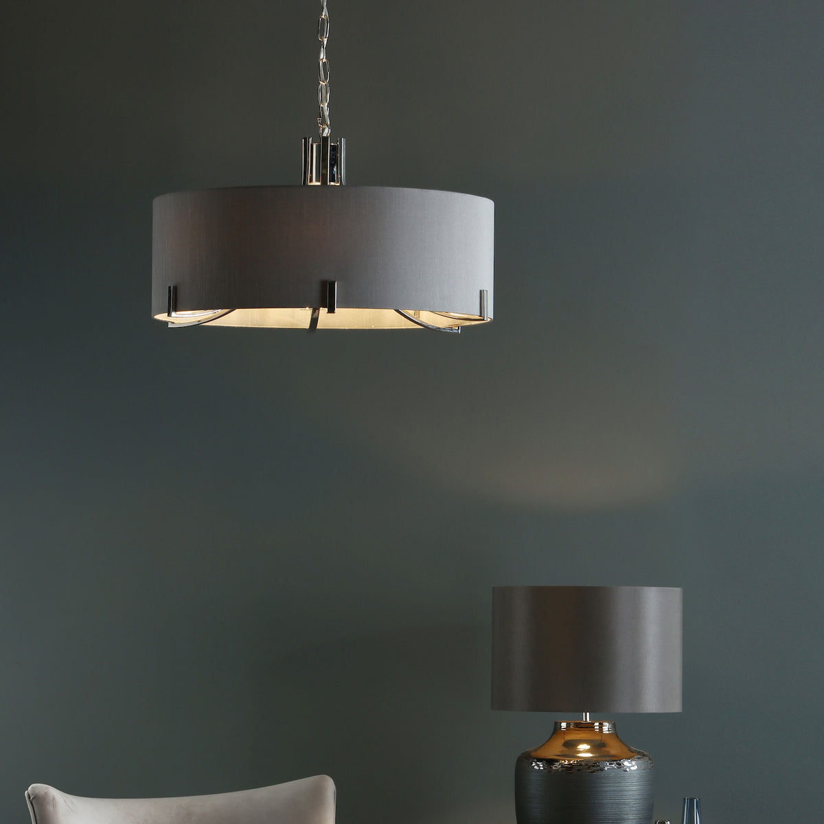 Gray drum pendant light and a matching table lamp with a metallic base.