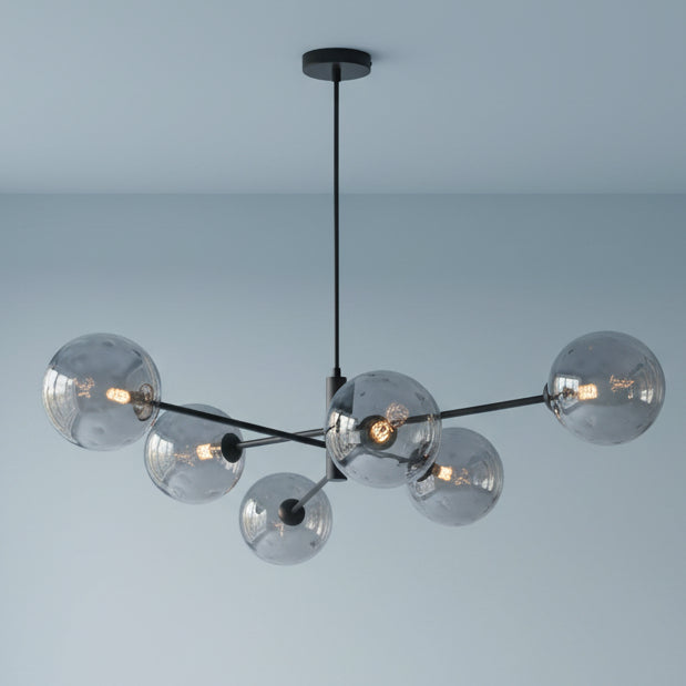 Modern black chandelier with six smoky grey glass globes, each containing an illuminated bulb.