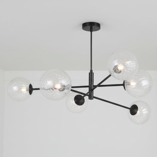 Modern black chandelier with six clear, ribbed glass globe shades and exposed bulbs.